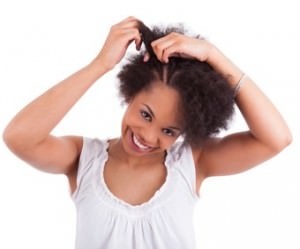 Young african american woman making braids