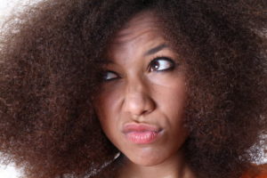 Black woman with kinky natural hair looking thoughtful